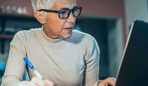 woman writing with pen in hand