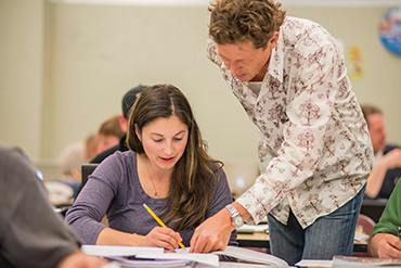 instructor and student discuss work in classroom