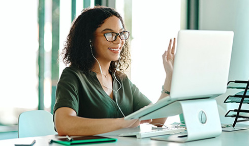 student attending online class in front of laptop