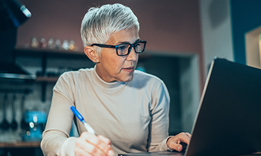 Person writing grant on laptop.
