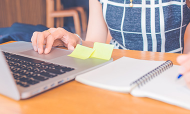Person editing with laptop and notebook. 