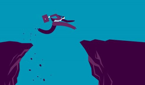 Person leaping between two cliffs.